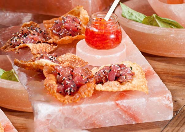 Savory appetizers served on a thick solid slab of pink Himalayan rock salt with matching salt bowls
